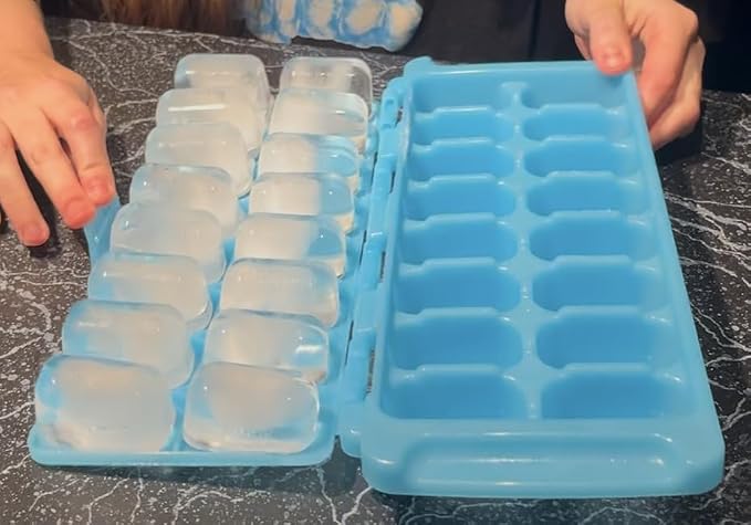 Photo showing the blue in color FlipCubes modern ice cube tray with patented no spill lid full of ice cubes and sitting on a countertop, demonstrating its easy release and stackable design stackable design.